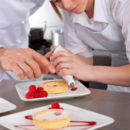 Cake Decorating Tools Set With EVA Pastry Bag 8 Piece used to pipe red berry sauce onto mini tarts with chef guiding a student