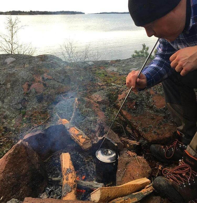 Camping Survival Fire Tube Telescopic 8 Section Blowpipe used to blow a campfire safely while heating a kettle by a lakeside