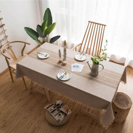 Cotton Linen Tassels Dining Tablecloth Rectangle 140x180cm on a cozy wooden dining table with simple tableware and plant centerpiece