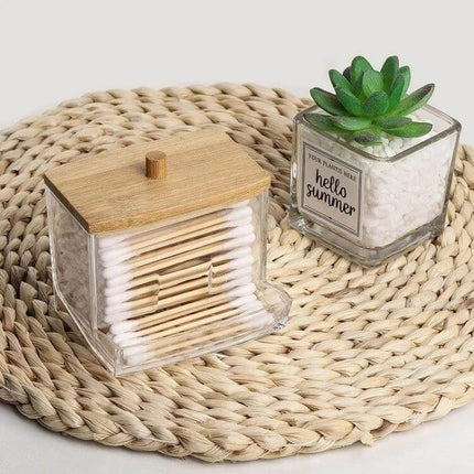 Cotton Swab Organizer, Acrylic Case With Bamboo Lid holding cotton swabs on woven mat next to small succulent decor