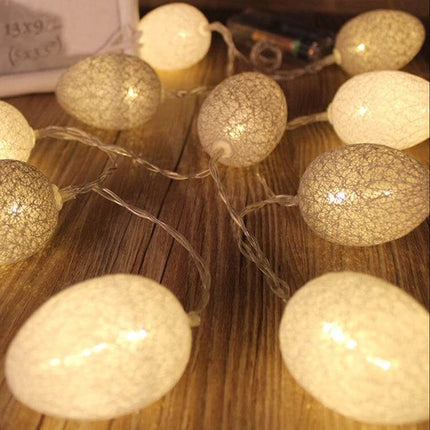 Cotton Thread Egg String Lights Battery Powered For Easter Decor - 10 egg-shaped cotton thread lights with warm battery-powered glow on wood surface