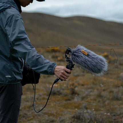 Deity Shotgun Microphone for Daily Vlogging and Interviews mounted with windscreen on handheld rig capturing outdoor interview audio