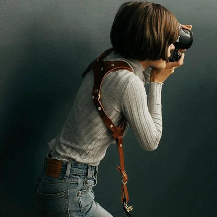 Adjustable Anti-Slip Leather Shoulder Harness for DSLR Cameras worn by photographer for hands-free stability and quick access