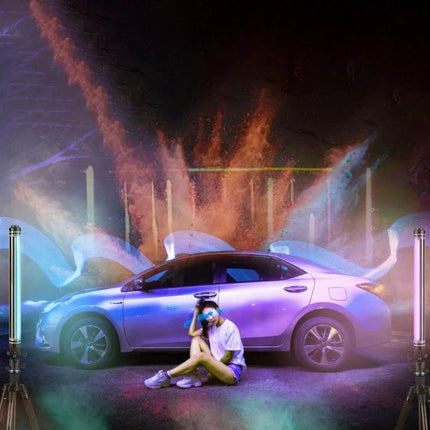 LUXCeO P7RGB Pro Handheld LED Light for Photo and Video Sessions showing portable RGB tubes lighting a car photoshoot with seated model