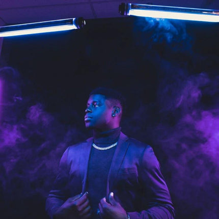 LUXCeO P7RGB Pro Handheld LED Light for Photo and Video Sessions glowing blue and purple on a model during a smoky studio shoot