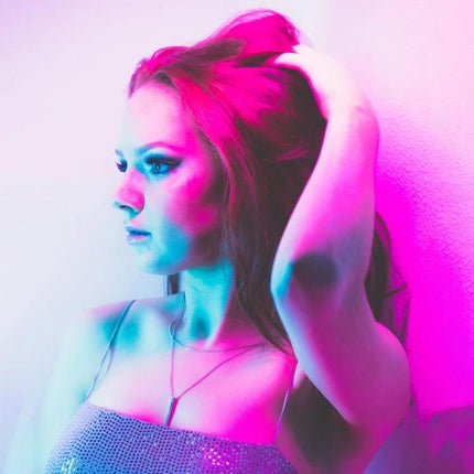LUXCeO P7RGB Pro Handheld LED Light for Photo and Video Sessions lighting model portrait with vibrant pink and cyan gel colors