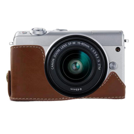 PU Leather Protective Half Case for Canon Cameras on silver Canon EOS M100 camera showing front view with brown synthetic leather half case