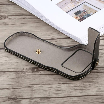Protective PU Leather Half Case with Thread for Canon Cameras shown open on wooden surface, grey PU leather with stitching and tripod screw