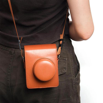 Vintage PU Leather Protective Case for Instax Cameras shown in brown with strap on person’s hip, protecting camera from dust and scratches