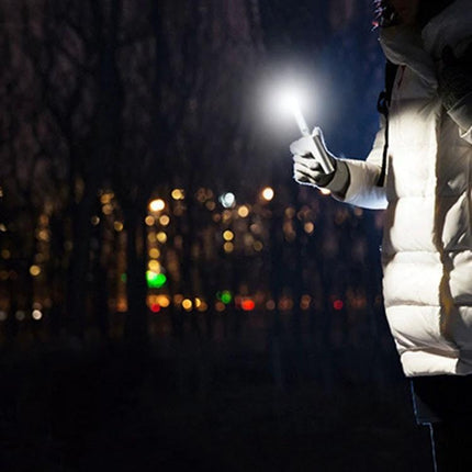 Compact USB Light for Nighttime Reading and Travel Essentials held by a traveler illuminating tasks in a dark park