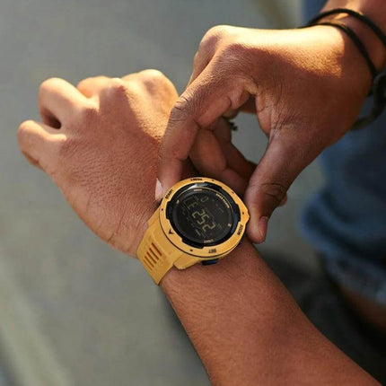 North Edge Mars Men's Waterproof Luminous Sports Watch on wrist being adjusted, yellow rugged sports watch with luminous display