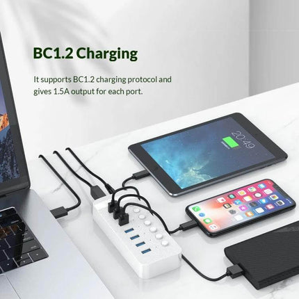 Orico 10-Port USB Hub for Connecting Multiple Devices with Individual Switches shown powering tablet, phone and external drive on desk