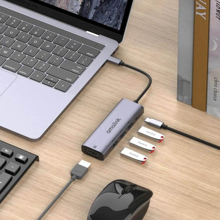 Amalink USB-C Hub for HDMI Connectivity and USB Ports Expansion connected to laptop showing HDMI, USB ports and multiple flash drives on desk