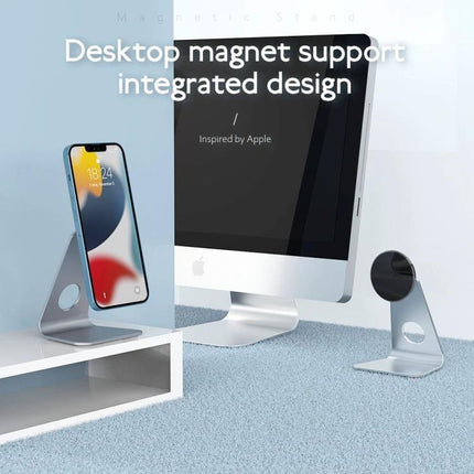 R-JUST Round Desktop Magnetic Holder for Stable Phone Placement shown on a silver aluminum stand holding a smartphone beside a desktop monitor