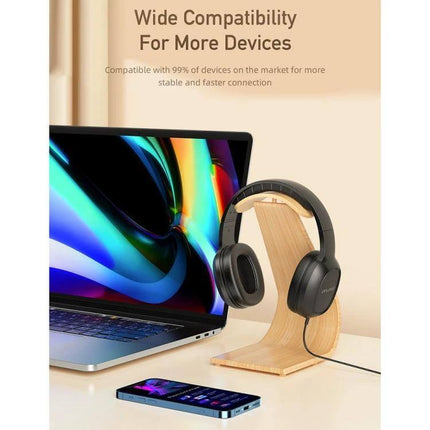 Awei Wired Stereo Headset With Comfortable Ear Cups For Commuting shown on stand beside laptop and smartphone for wide compatibility