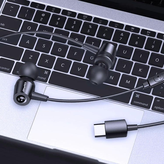 Awei In-Ear Earphones for Daily Commutes and Work — black in-ear earphones with inline controls and USB‑C plug on laptop keyboard