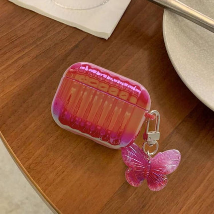 Compact Case for Protecting Earphones in Daily Routines - glossy pink protective earphone case with butterfly charm on wooden table