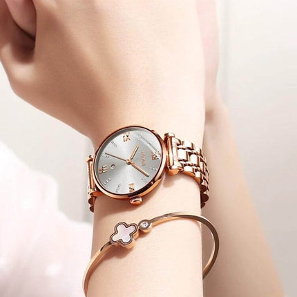 JIN SHI DUN Elegant Waterproof Women's Quartz Watch on wrist with tungsten steel strap and Roman numerals, rose gold finish, suitable for everyday wear