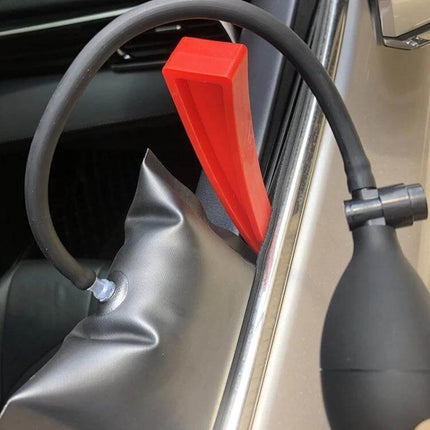 Paintless Dent Repair Kit for Car Hail Damage with 18 Tools shown using a red wedge and inflatable bag to push out a door dent