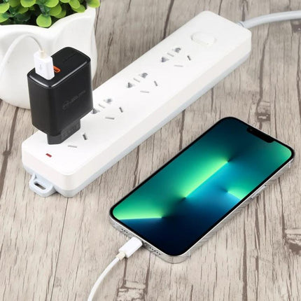A Versatile USB Charger for Everyday Home and Travel Needs - compact black USB charger plugged into power strip charging smartphone on wooden table