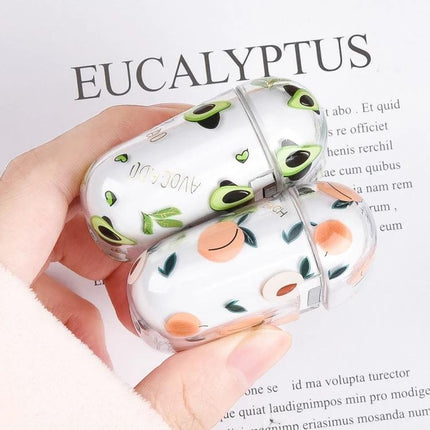 Fruit-Patterned Protective Case for Everyday Earbud Use — hand holding clear avocado and peach printed protective earbud cases