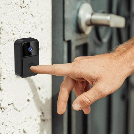 Wireless Smart Video Doorbell for Easy Home Monitoring with Wide Angle showing finger pressing button on outdoor unit with visible camera lens