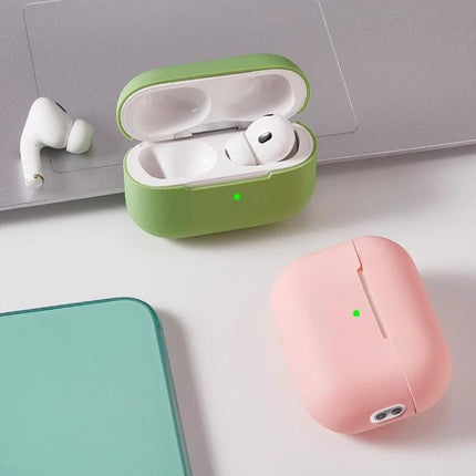 Durable Silicone Case for Protecting Earbuds in Daily Life showing green open case and pink closed case beside earbuds and laptop