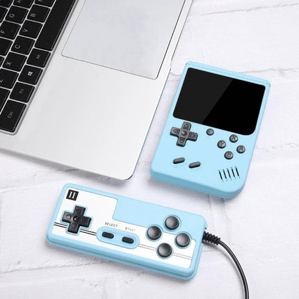 Macaron Mini Handheld Game Console with 800 Built-in Games shown in pastel blue with handheld and wired controller next to laptop