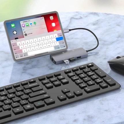 Onten USB-C Portable Multifunctional Docking Station for Devices connected to tablet, keyboard and mouse on a home office desk