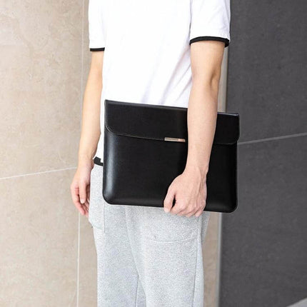 Protective PU Leather Laptop Sleeve for 13-16 Inch Devices in black being carried by commuter with soft interior lining and slim profile