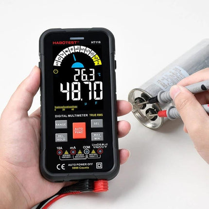 HABOTEST HT116 Large Screen Digital Multimeter held displaying voltage and temperature while testing an electronic component