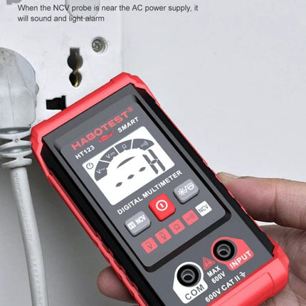 HABOTEST Mini Digital Multimeter for Electrical Measurements held near an AC outlet showing NCV and digital display