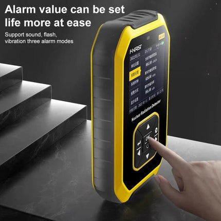 Portable Geiger Counter for Home Radiation Detection handheld yellow device with display and keypad being pressed, showing alarm settings