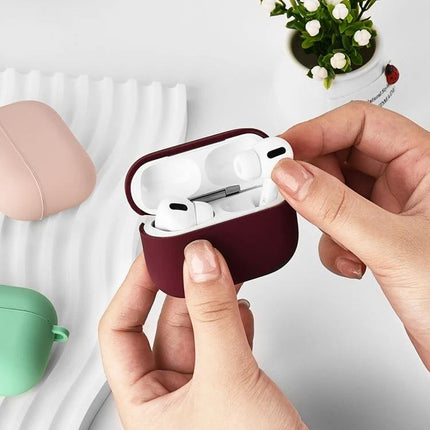 Protective Silicone Case for Earbuds During Daily Activities - burgundy case protecting wireless earbuds being placed inside, 360-degree coverage