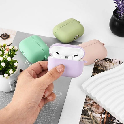 Protective Silicone Case for Earbuds During Daily Activities shown in pastel purple being held with matching green, pink cases in background