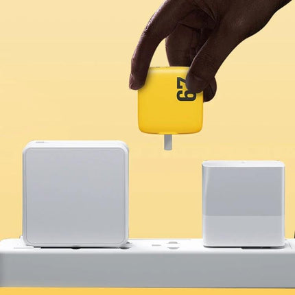 WK WP U141 67W GaN Charger With Dual Type C Ports And USB A CN US EU UK Plugs - yellow 67W GaN charger held above power strip