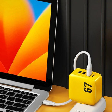WK WP U141 67W GaN Charger With Dual Type C Ports And USB A CN US EU UK Plugs compact yellow 67W GaN charger beside laptop, dual Type-C and USB-A ports