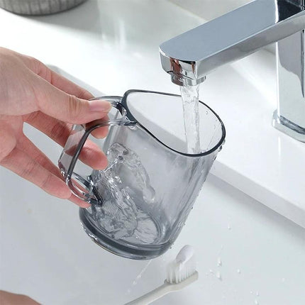 Daily Essentials Cup for Mouthwash and Toothbrush Storage being rinsed under faucet, curved rim and built-in slot visible for toothbrush organization