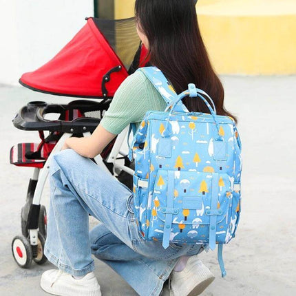 Multifunctional Mommy Bag Large Capacity Baby Care Backpack with insulated bottle pocket on a parent wearing blue patterned diaper backpack