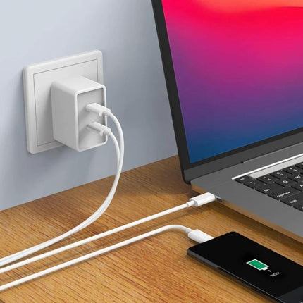Essential Charging Cable for Phones in Daily Life plugged into wall charger charging phone and laptop on desk
