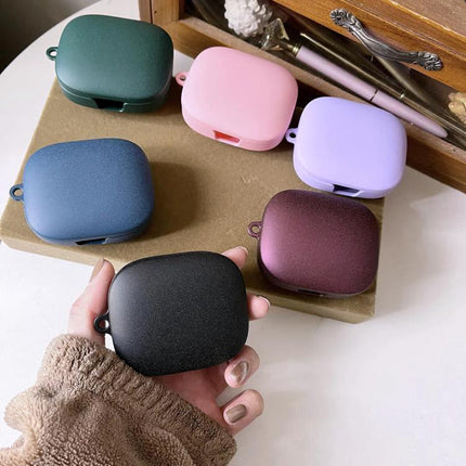 Essential Protective Case for Daily Earphone Travel in matte black held by hand with five pastel color cases displayed