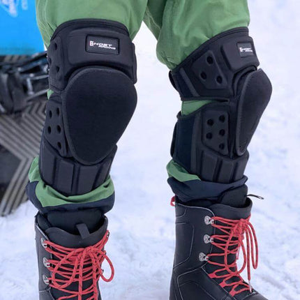 Ghost Racing Kevlar Knee Pads For Motorcycle Riding worn over pants showing black knee protection with boots on snowy terrain