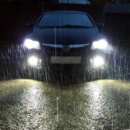 Car LED Headlight And Fog Light For Everyday Driving IP68 - front view in heavy rain showing bright headlights and fog lights on a sedan