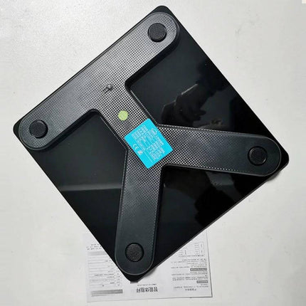 Smart Body Fat Scale Battery Powered For Everyday Home Use showing black glass scale top view with sensors and instruction sheet