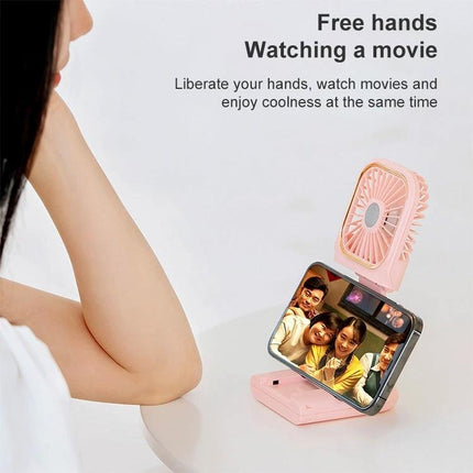 Portable F30 Hanging Neck and Handheld Fan for Daily Cooling shown in pink desktop mode holding a phone for hands-free movie watching