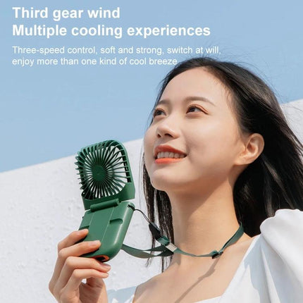 Portable F30 Hanging Neck and Handheld Fan for Daily Cooling in green held by smiling woman using hanging neck mode outdoors