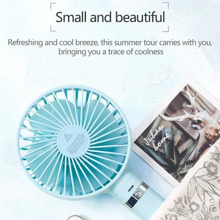 Compact Portable Foldable Handheld Electric Fan with Night Light shown in mint blue on a desk, foldable handheld design with soft night light and rechargeable battery
