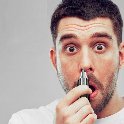 Electrical Nose Hair Trimmer Battery Powered for Easy Grooming being used by a man holding the compact trimmer to his nostril, 360-degree rotating blade, travel-ready 120×50×30mm