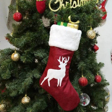 Embroidered Christmas Stocking Ornament Gift Bag Snowflake Style red stocking with white cuff and reindeer hanging on decorated Christmas tree