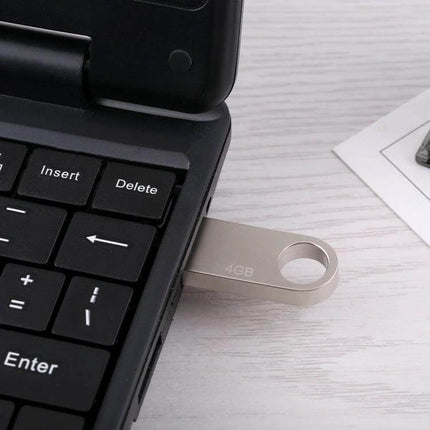 Compact 4GB Metal USB Flash Drive for Storing Files and Photos inserted into laptop USB port, durable metal body for travel and photo backups